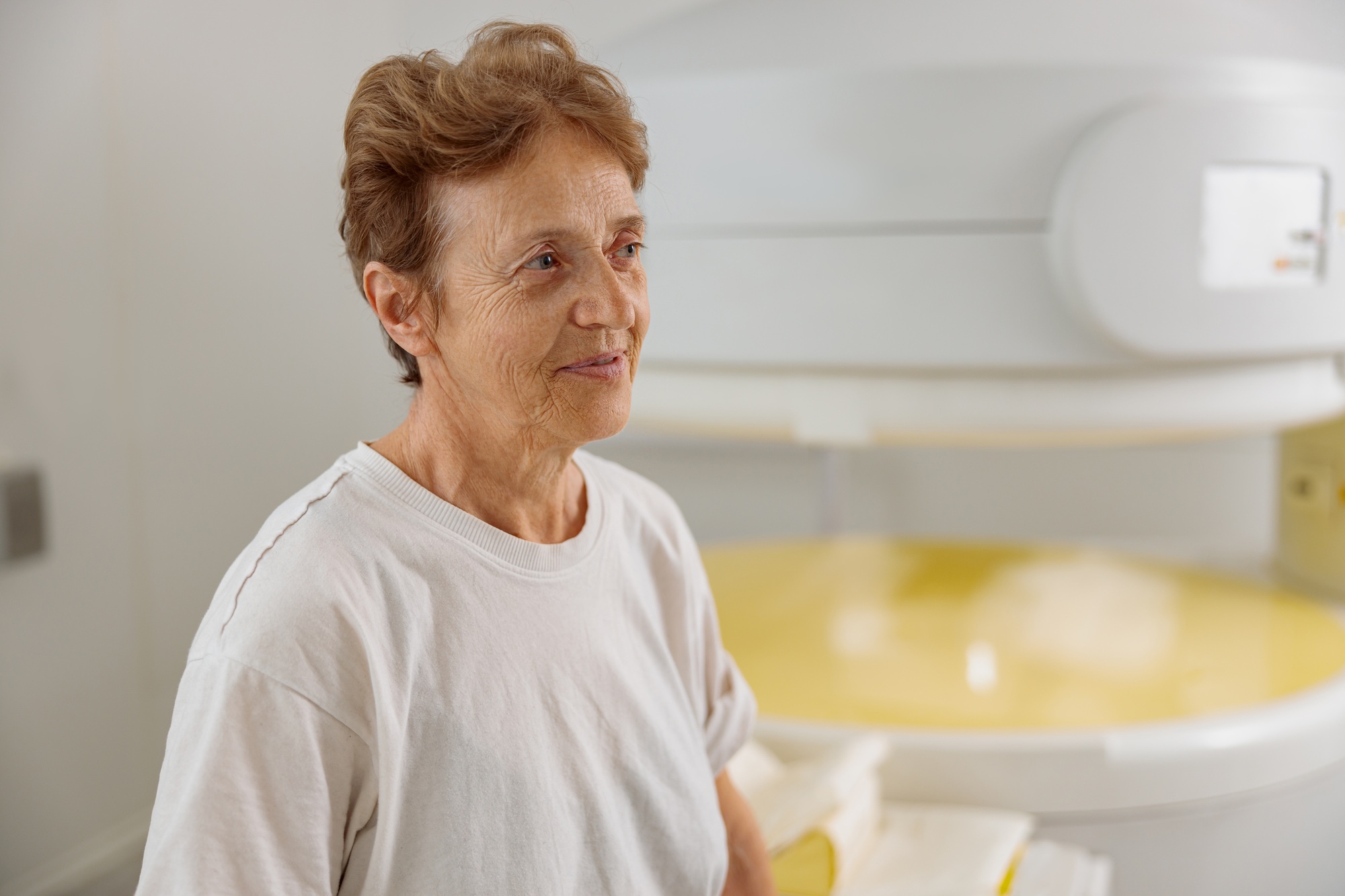 Happy woman patient looking away after doing procedure of MRI or CT Scan in medicine clinic